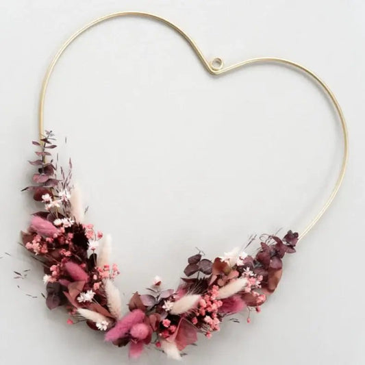 Liebeserklärung in Blüten: Goldenes Herz mit Trockenblumen in Rosa und Rot